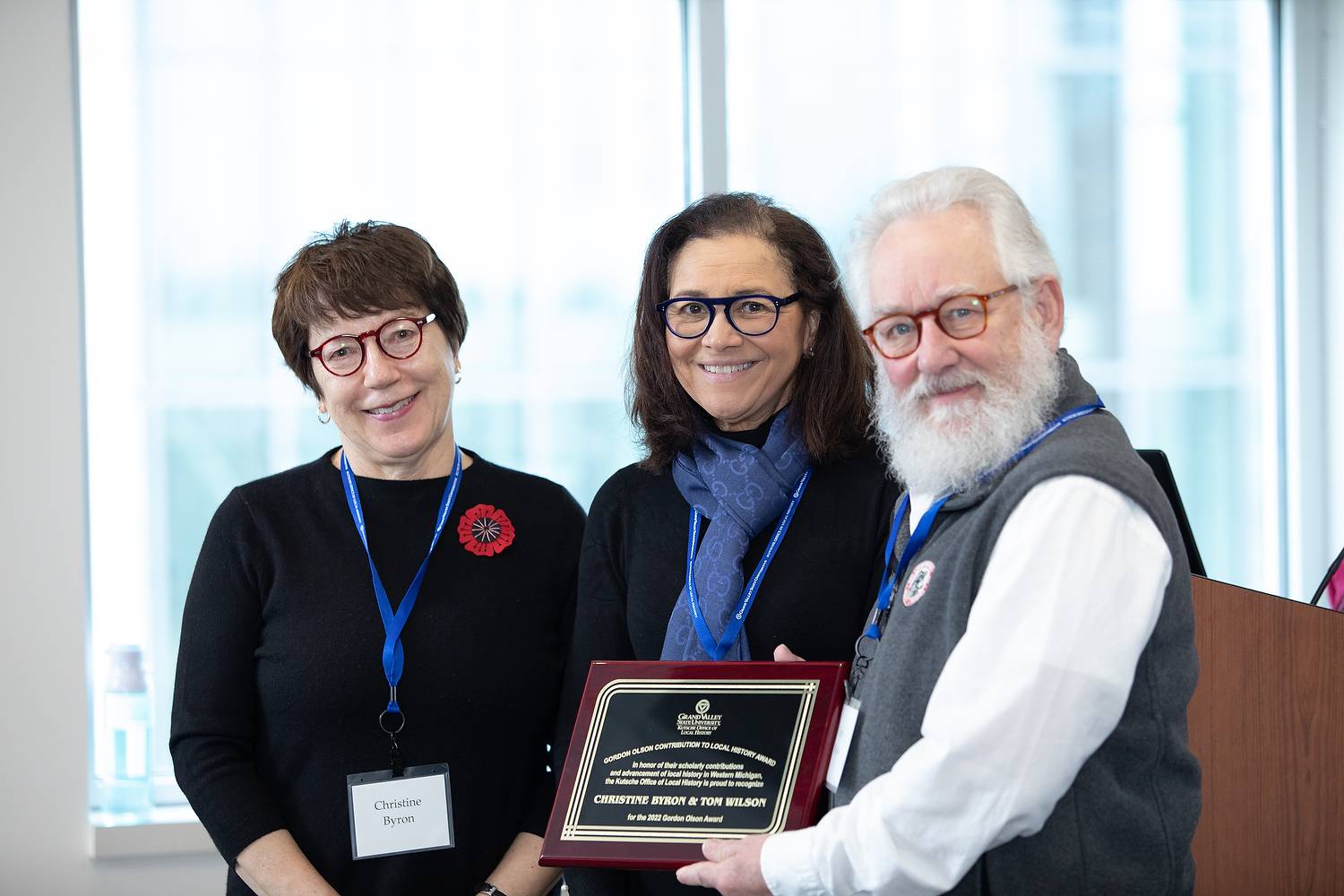 Christine Byron, Peg Padnos, and Tom Wilson holding the 2022 Gordon Olson Award plaque.